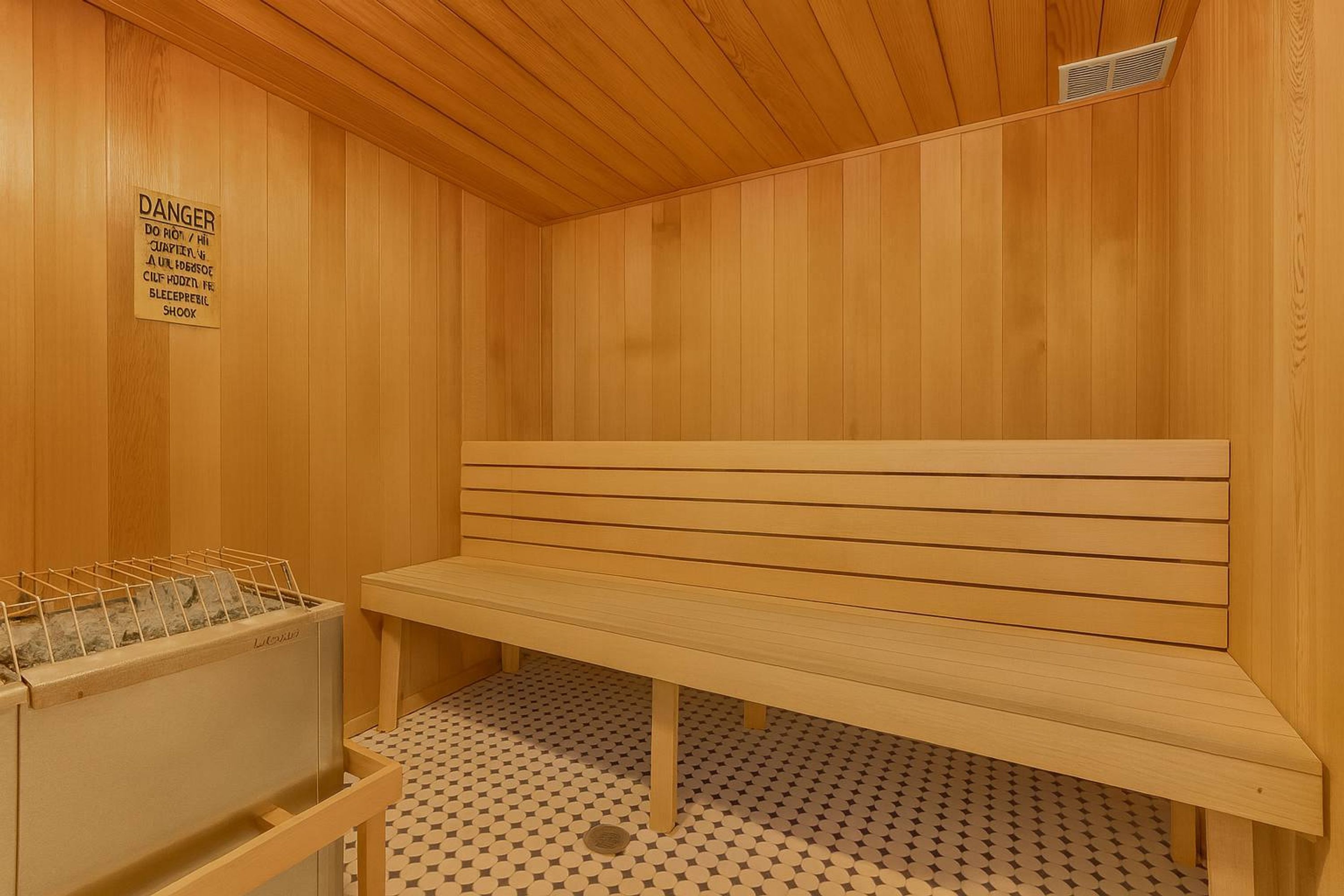 Eine Sauna mit Holzwänden und einer Sitzbank. An der Wand hängt ein Schild und eine Handtuchstange mit Handtüchern.