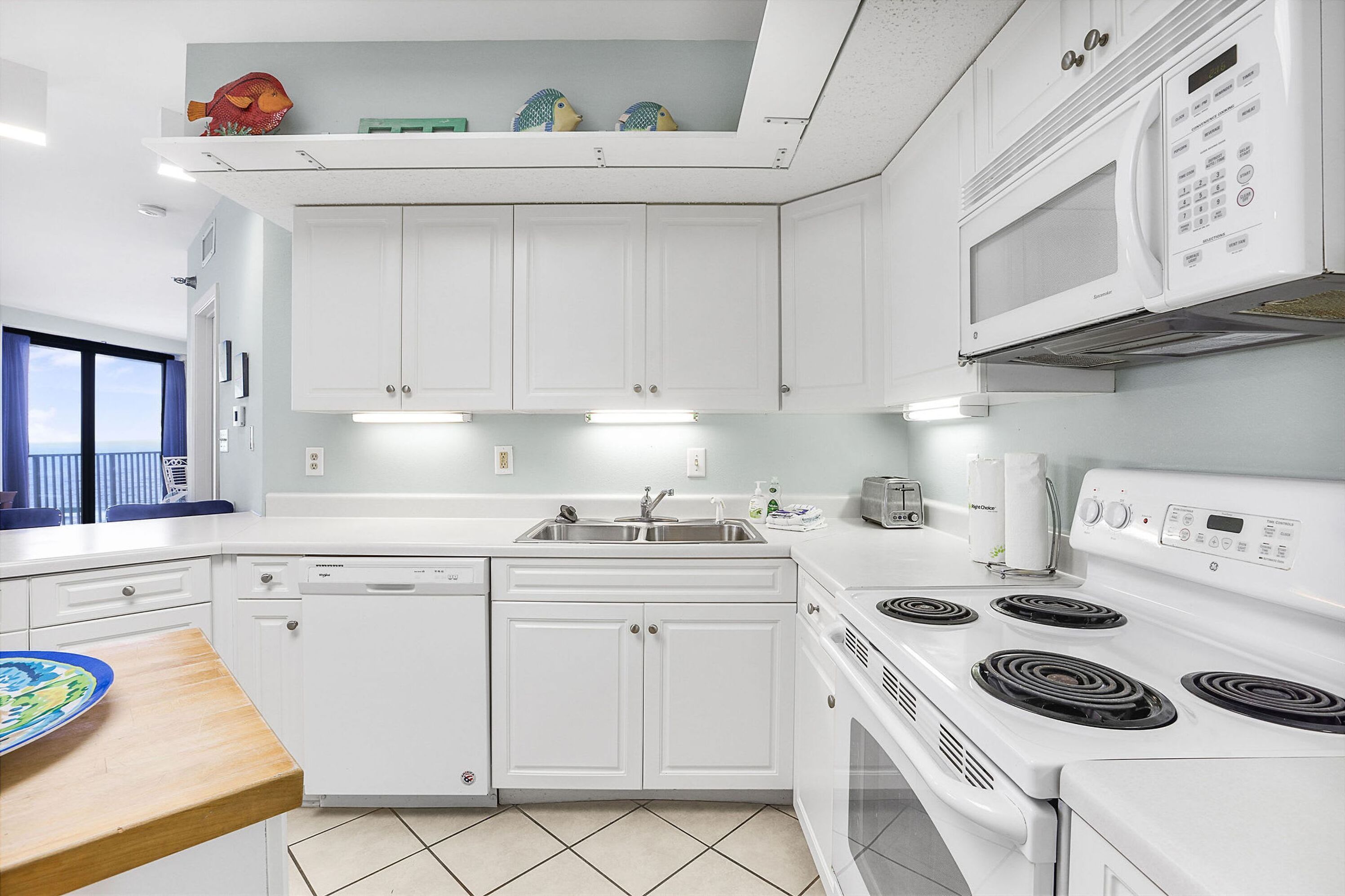 A modern kitchen with white cabinets, a built-in microwave, a stove, and a dishwasher.
