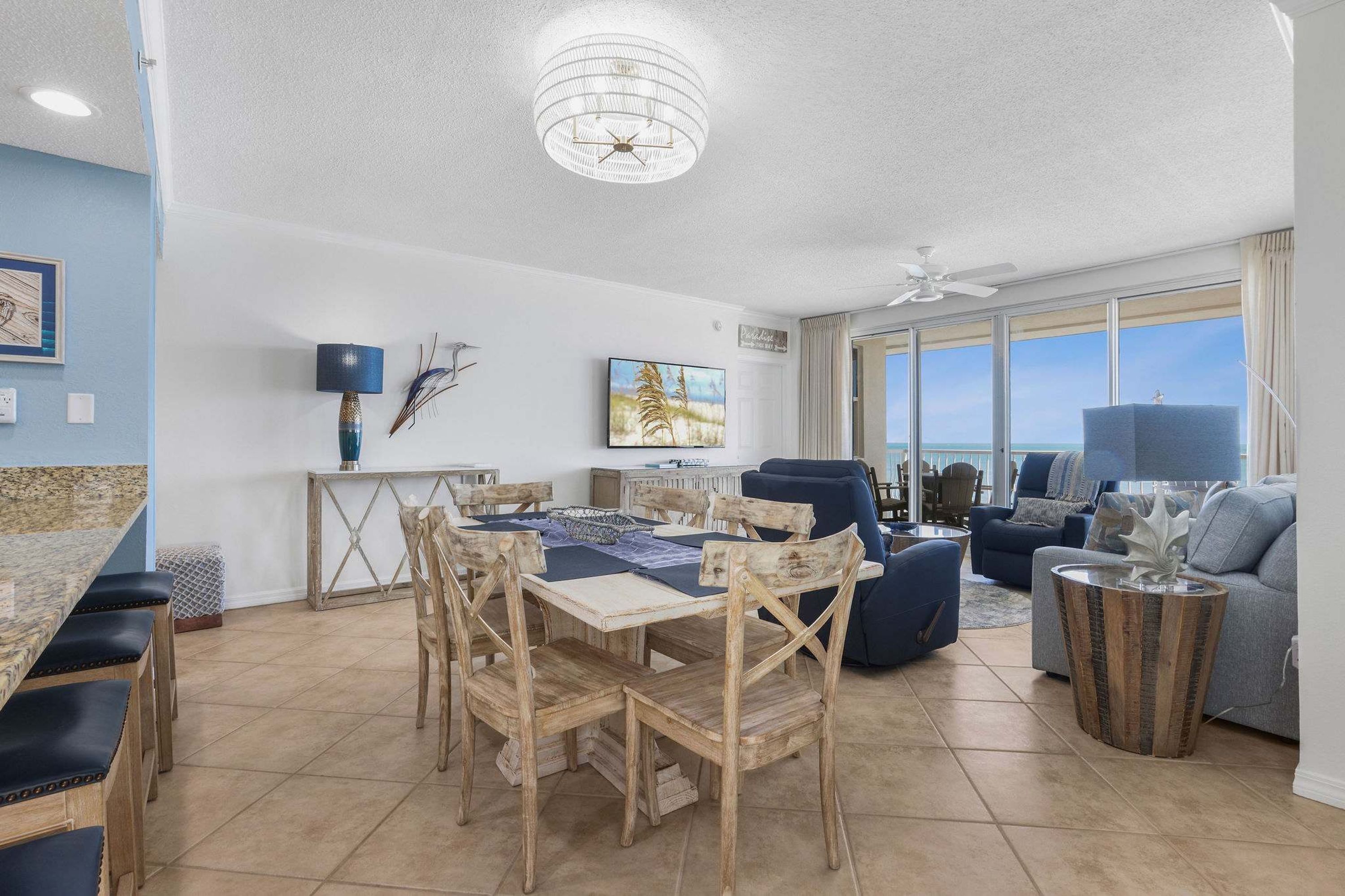 A spacious living area with a dining table, chairs, a sofa, and a TV.