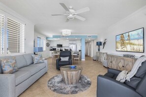 A spacious living area with a sofa, a coffee table, and a TV. - Emerald Key 603 Beachfront Balcony 6th Floor Corner Unit (Orange Beach)