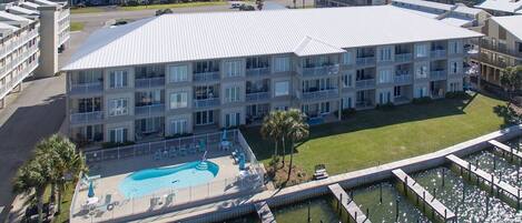 Un hotel de varios pisos con zona de piscina, que incluye una terraza y una fuente de agua.