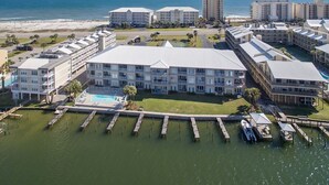 A coastal hotel with multiple buildings, a swimming pool, and docked boats. - Dolphin Harbor 1B Bay Beach Access Sleeps 10 Three Bedrooms 3 Baths (Orange Beach)