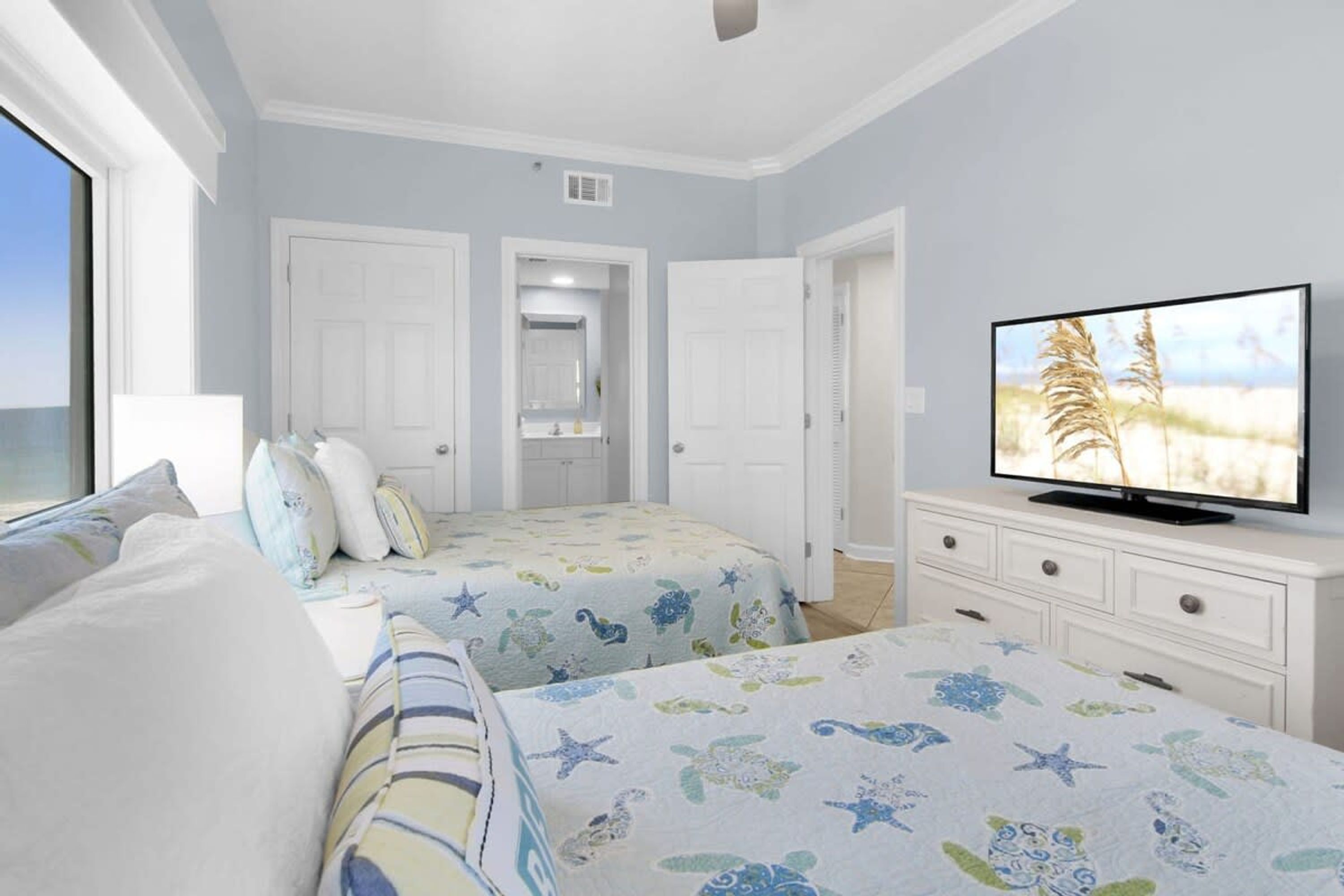 Un dormitorio con dos camas, televisión y cómoda.
