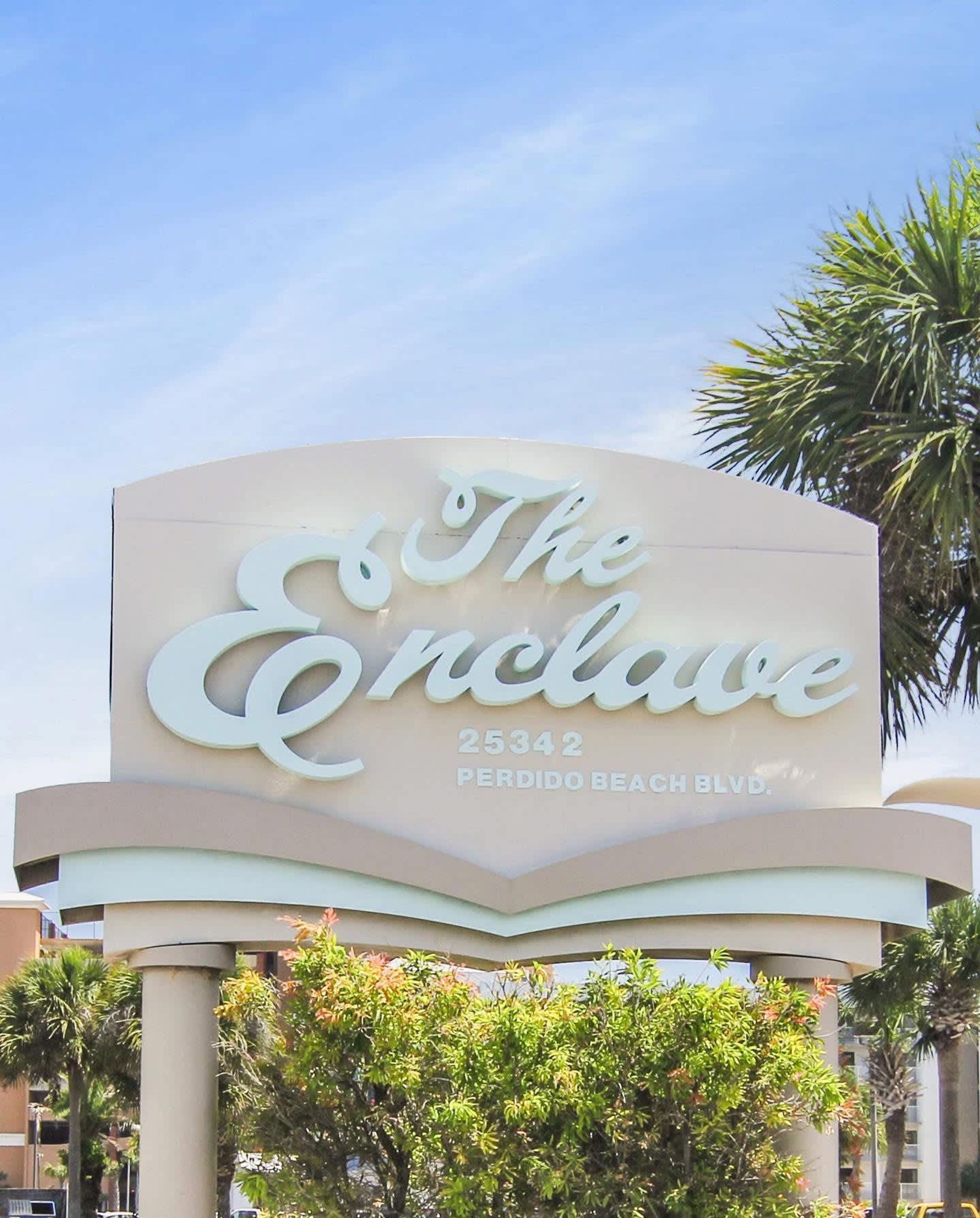 Une grande enseigne indiquant « The Enclave », avec l’adresse « 25342 Perdido Beach Blvd. ».