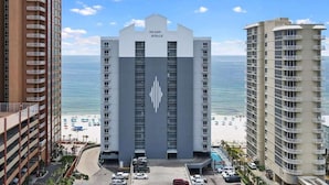 A hotel with a central tower labeled "Island Royale," surrounded by other buildings, with a beach and ocean in the background. - Island Royale- Beachfront Penthouse (Gulf Shores)