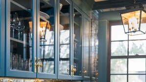 A kitchen with teal cabinetry, stainless steel appliances, and a window with a view. - The Royce - Two Luxury Family Homes in Downtown Newport (Newport)