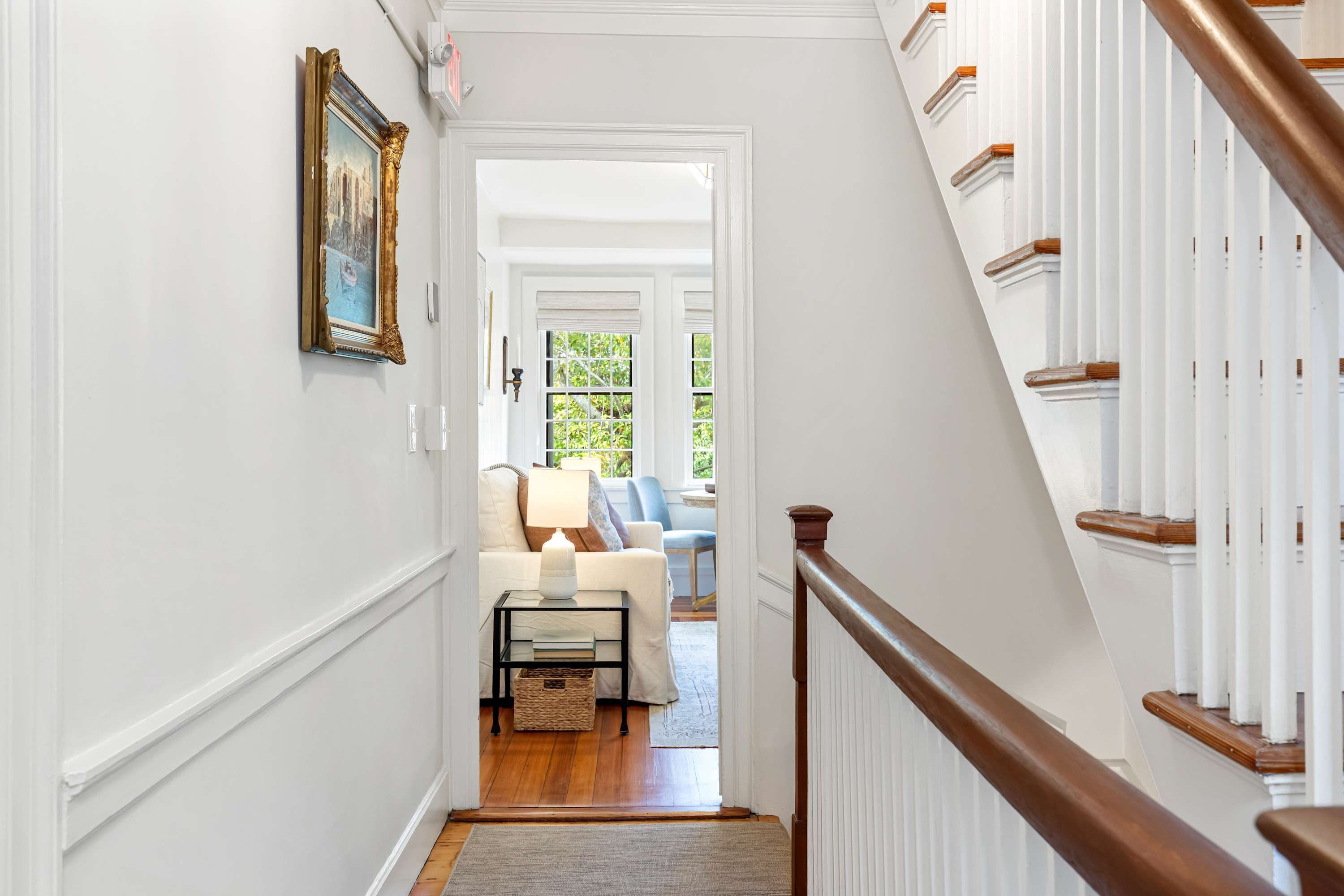A hallway leading to a living room with a staircase.