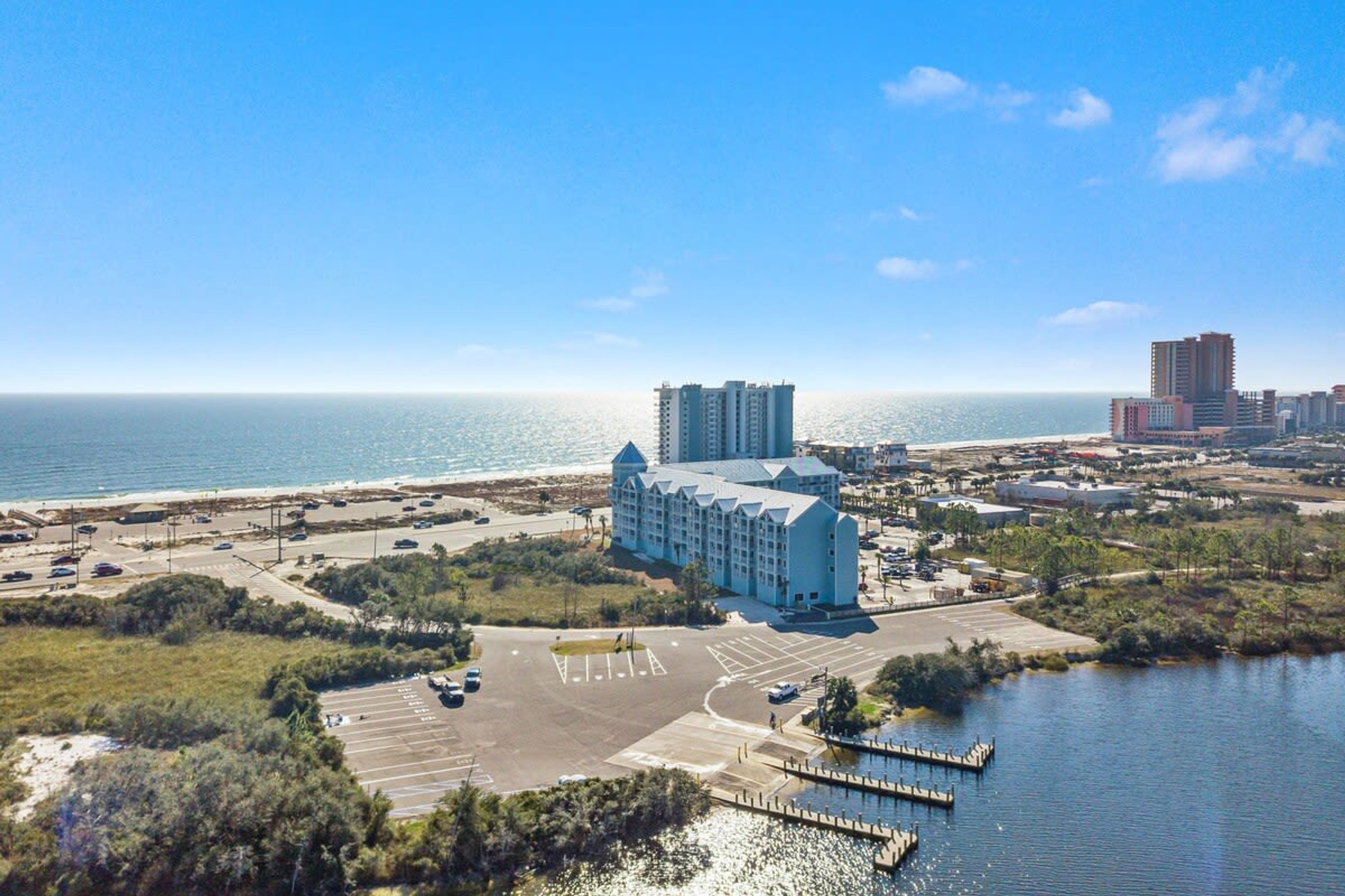 A coastal hotel with a marina, parking lot, and ocean view.