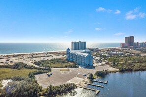 A coastal hotel with a marina, parking lot, and ocean view. - Grand Caribbean 201- Beach bay View 1 BR w Bunk (Orange Beach)