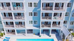 A multi-story hotel with a pool and sun loungers. - Grand Caribbean 201- Beach bay View 1 BR w Bunk (Orange Beach)