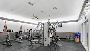 Et fitnesscenter med forskellig træningsudstyr, heriblandt løbebånd, motionscykler og vægtmaskiner.