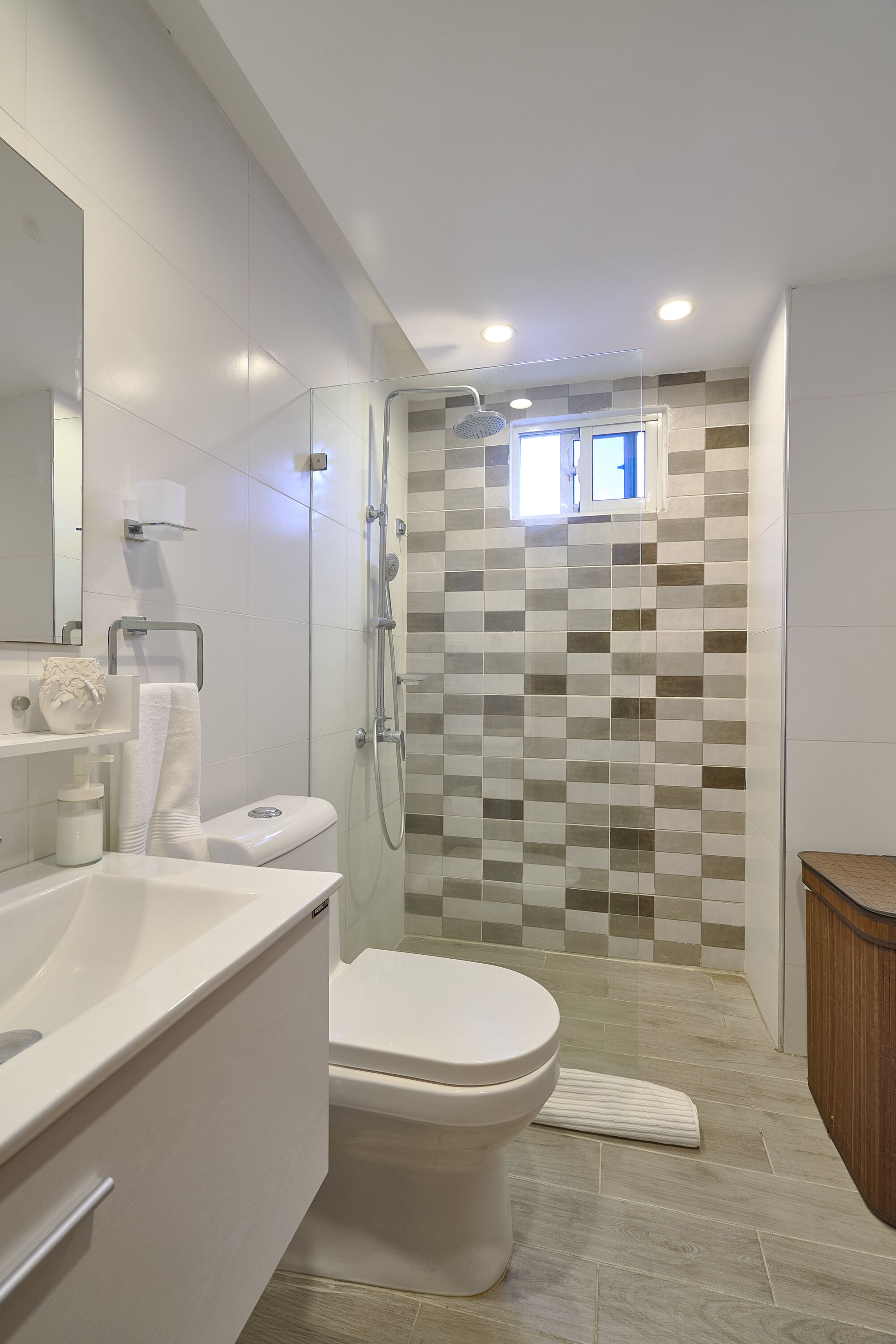 A modern bathroom with a shower, toilet, and sink.