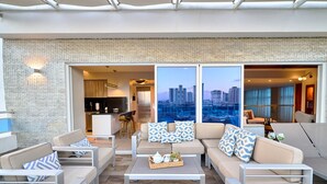 A modern outdoor seating area with a city view, a kitchen, and a dining area. - Acqualina s View Santo Domingo (Santo Domingo)
