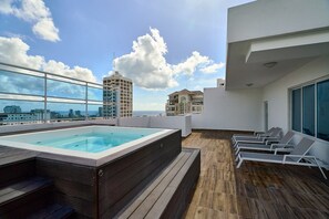 A rooftop terrace with a hot tub, lounge chairs, and a view of the city skyline. - LUX City Skyline Downtownsd Priv Jaccuzi Gym (Santo Domingo)