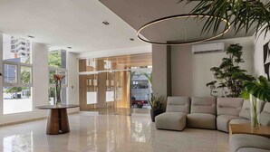 A modern lobby with a glass table, a sofa, and a potted plant. - LUX City Skyline Downtownsd Priv Jaccuzi Gym (Santo Domingo)