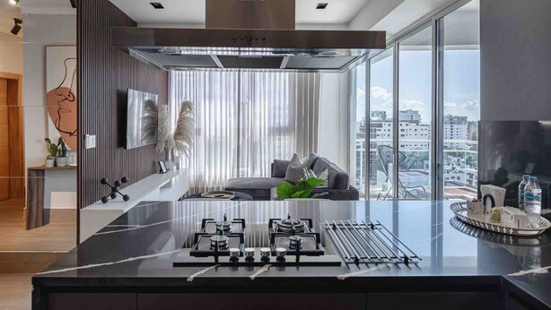 A modern kitchen with a gas stove, a stainless steel range hood, and a large window offering a city view. - LUX City Skyline Downtownsd Priv Jaccuzi Gym (Santo Domingo)