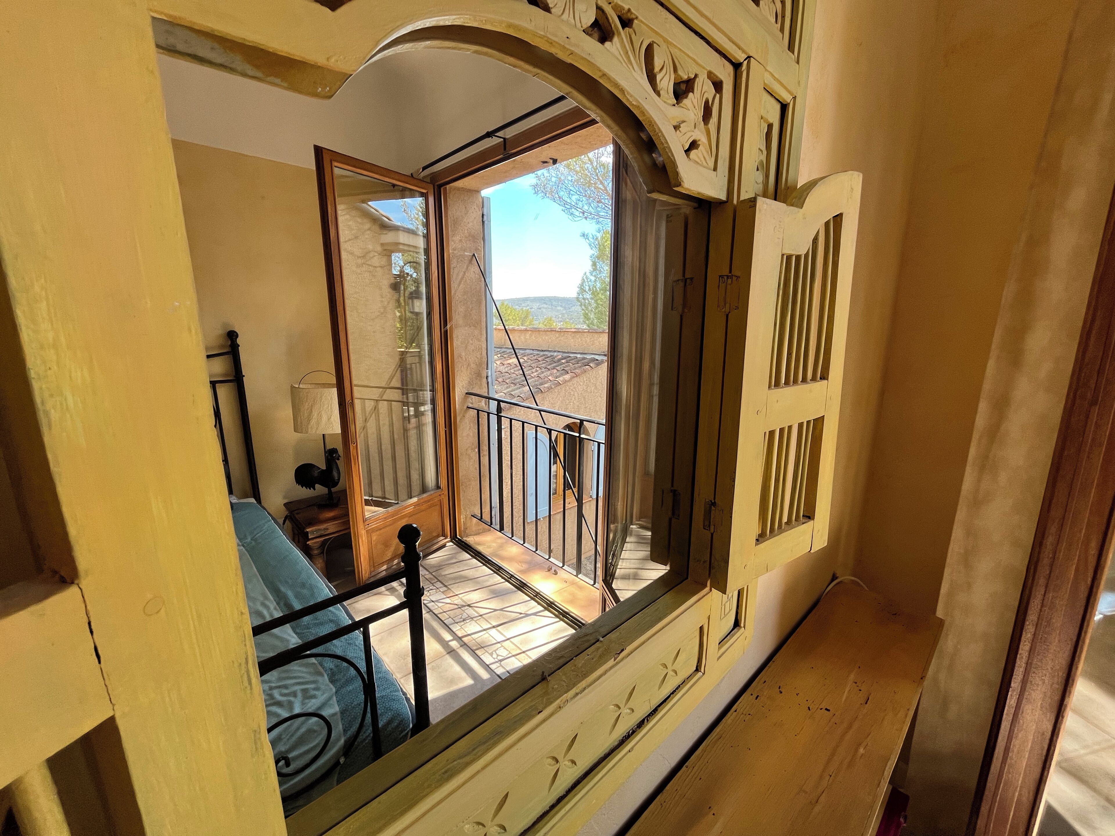 Une chambre avec un lit, une fenêtre et un balcon.