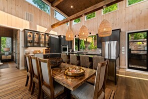A spacious kitchen with wooden walls, modern appliances, and a dining area with a large wooden table and chairs. - New Listing Discount-Luxury-Modern-Mountain and Lake View w/ Jacuzzi & Fireplace (Blue Ridge)