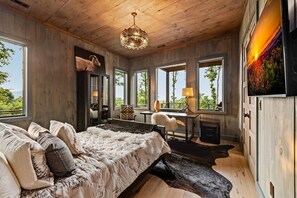 A bedroom with a large bed, a desk, and a fireplace. - New Listing Discount-Luxury-Modern-Mountain and Lake View w/ Jacuzzi & Fireplace (Blue Ridge)