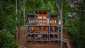 A multi-level wooden cabin with balconies, built into a hillside surrounded by trees. - New Listing Discount-Luxury-Modern-Mountain and Lake View w/ Jacuzzi & Fireplace (Blue Ridge)