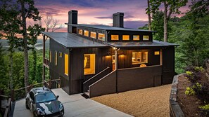 A modern cabin with a staircase leading to the entrance, surrounded by trees and a view of the landscape. - New Listing Discount-Luxury-Modern-Mountain and Lake View w/ Jacuzzi & Fireplace (Blue Ridge)