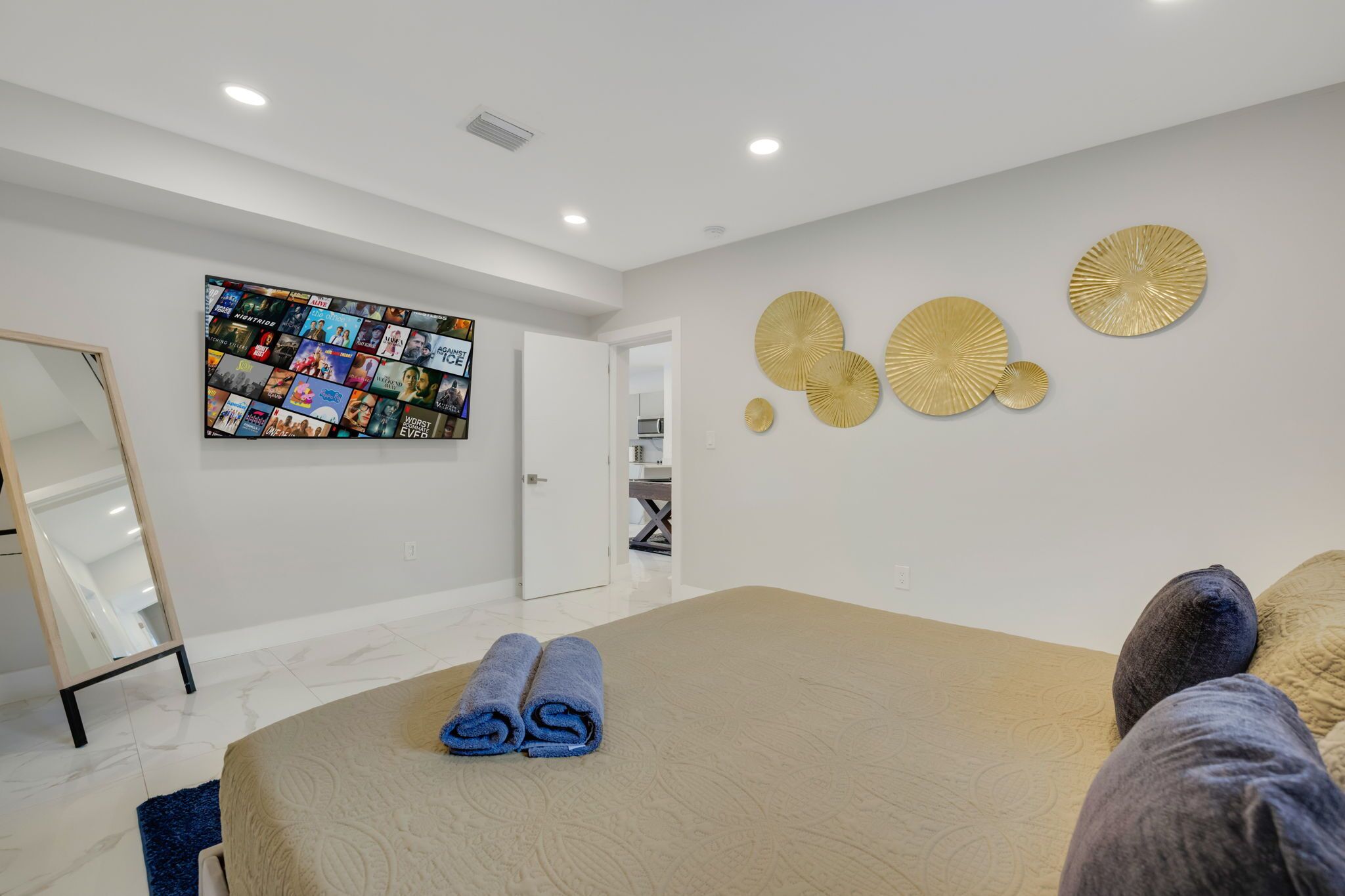 Una habitación de hotel moderna con una cama grande, una composición de arte en la pared y placas decorativas.