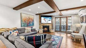 A modern living room with a fireplace, large windows, and a cozy seating area.