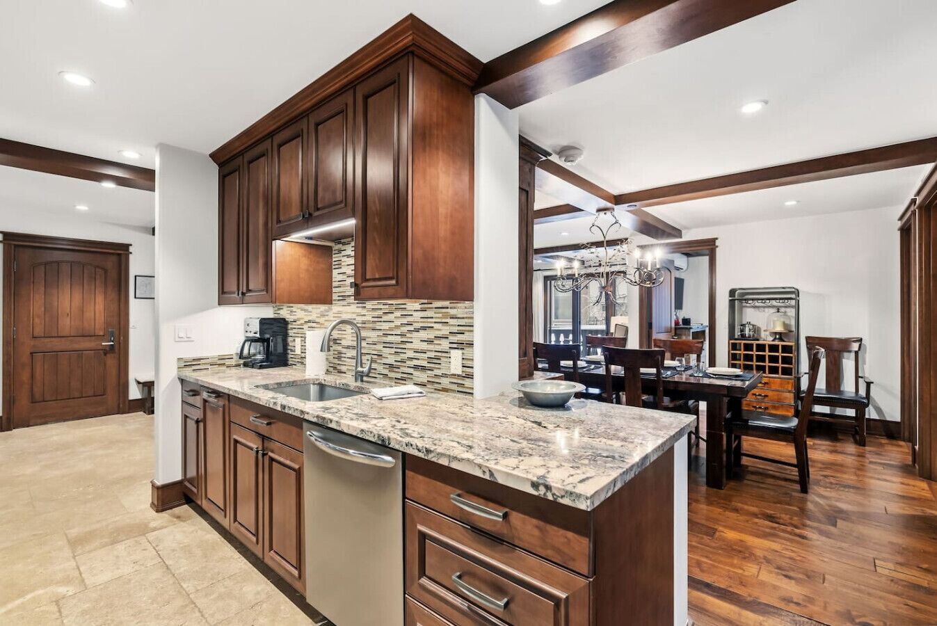 A kitchen with wooden cabinets, a granite countertop, and a dishwasher.