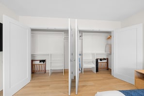 A room with a wooden floor, white walls, and a closet with open doors. - Pacific Tides -Entire 9-Unit Apartment Complex w/ Parking + A/C in Pacific Beach (San Diego)