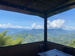 Una habitación con un ventanal grande que da a un paisaje montañoso.