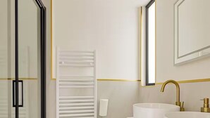 Ein modernes Badezimmer mit Duschkabine aus Glas, einer weißen Toilette und einem Waschtisch mit zwei Becken.