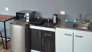 A compact kitchen with a built-in microwave, toaster, and kettle, a sink, and a wooden ceiling. - Cozy cottage in Sto Domingo, quiet environment, close to beach and commerce. (San Antonio)
