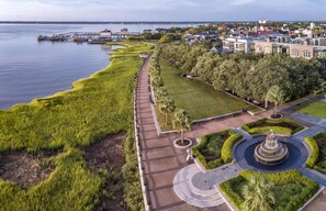 An aerial view of a waterfront park with a walking path, a fountain, and surrounding greenery. - Best Location, 2bd in Heart of French Quarter! (Charleston)