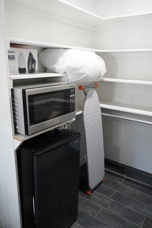 A compact kitchenette with a microwave, an iron, and a small refrigerator. - San Jose Studio • Near PayPal Park • EV & BBQ (San Jose)