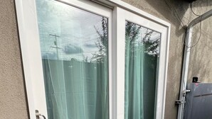 A sliding glass door with a doormat that reads 'Good luck and only.'