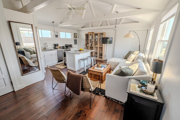 A spacious living area with a kitchen, dining table, and seating. - Best Location in Ptown — Harbor Views, Beach Access & Steps from the Ferry (Provincetown)