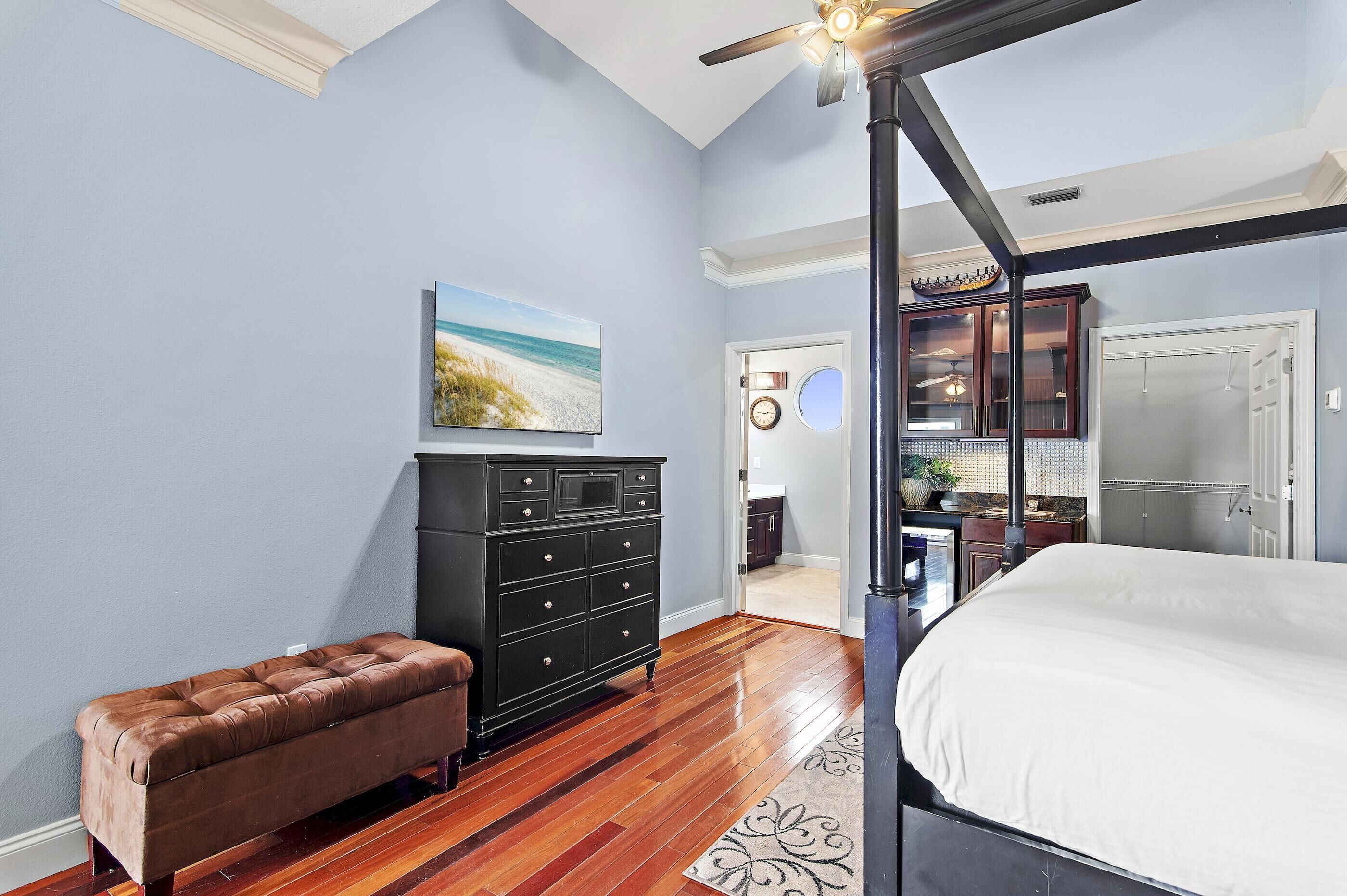 Een slaapkamer met een hemelbed, een dressoir en een bankje.