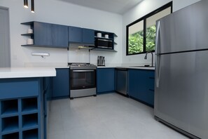 Eine moderne Küche mit blauen Schränken, einem Edelstahl-Kühlschrank und einem eingebauten Backofen.