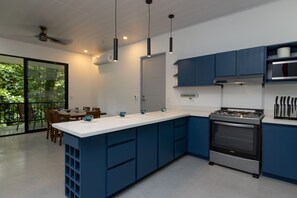 Eine moderne Küche mit blauen Schränken, einer weißen Arbeitsplatte und einem eingebauten Backofen.