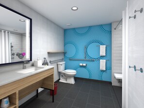 Ein modernes Badezimmer mit Waschbecken, Toilette und Duschbereich. An der Wand befinden sich Haltegriffe und ein Handtuchhalter.