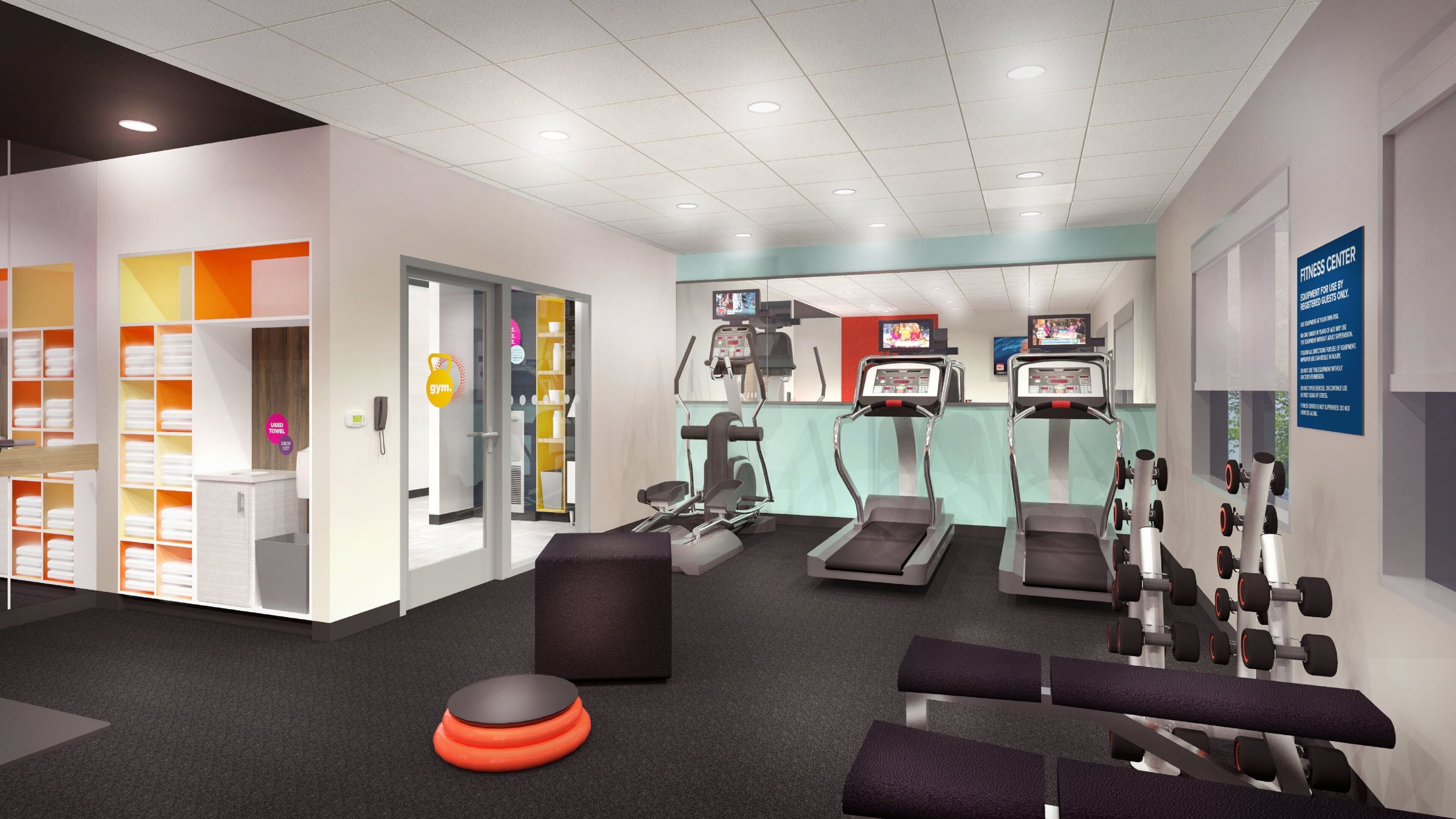 Un centre de remise en forme équipé de tapis de course, de vélos d’exercice et de poids libres.