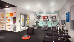 Een fitnessruimte met loopbanden, spinningfietsen en gewichten.