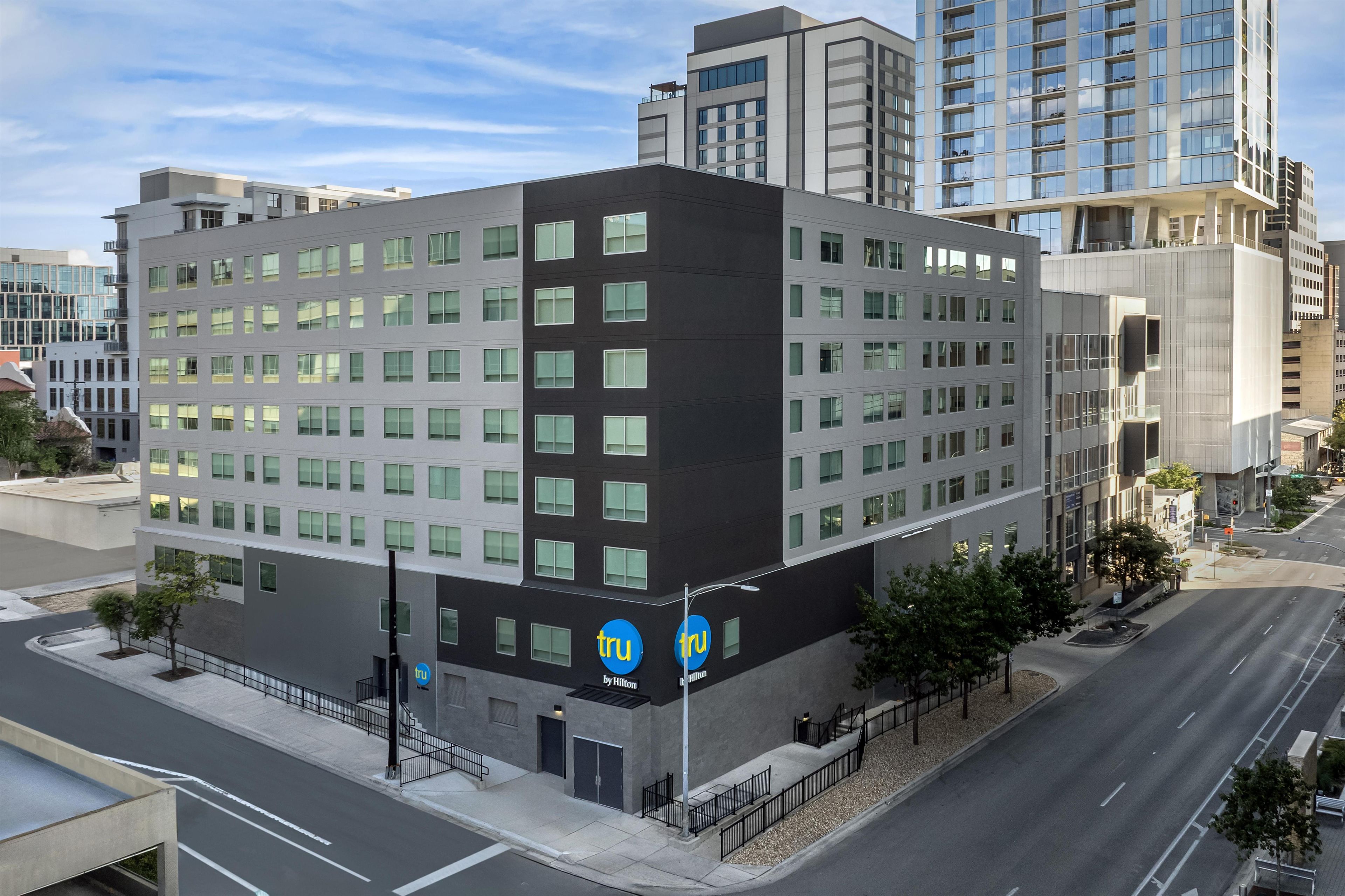 A modern hotel building with a flat facade, multiple windows, and a visible entrance.