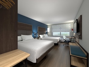 Ein Hotelzimmer mit zwei Betten, einem Schreibtisch, einem Stuhl, einem Fernseher und einem Fenster mit Blick.
