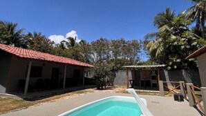 A swimming pool with a red-tiled roof structure in the background.