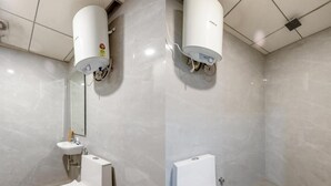 Et moderne badeværelse med toilet, vask og to væghængte varmeapparater.