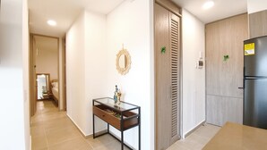 Una cocina moderna con refrigerador empotrado, armarios de madera y una pequeña mesa de madera con un adorno.