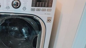 Een voorlader wasmachine met een digitaal display, bedieningspaneel en een etiket met 10 jaar garantie.