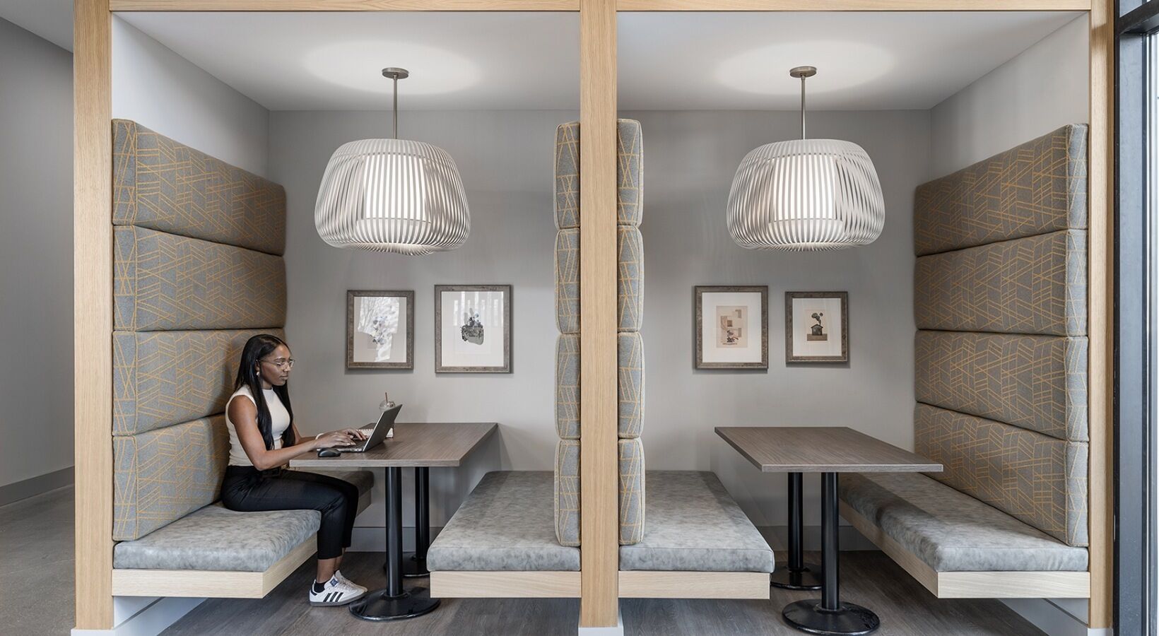 A modern interior with seating areas, tables, and pendant lighting.