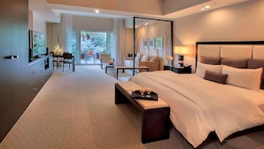 A modern hotel room with a large bed, a desk, a chair, and a view of the outdoors. - King Studio Suite w/ Kitchen & Jetted Tub + Spa (Miami)